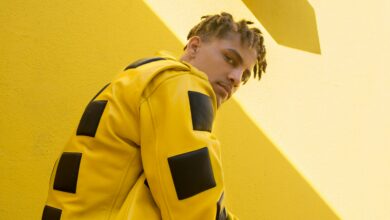 A model in a bold yellow and black leather jacket against a yellow wall, showing what is alt fashion