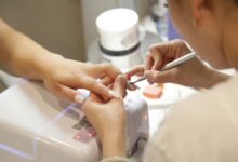 cuticle tool lifting soft gel from a nail, part of how to remove gel x nails at home