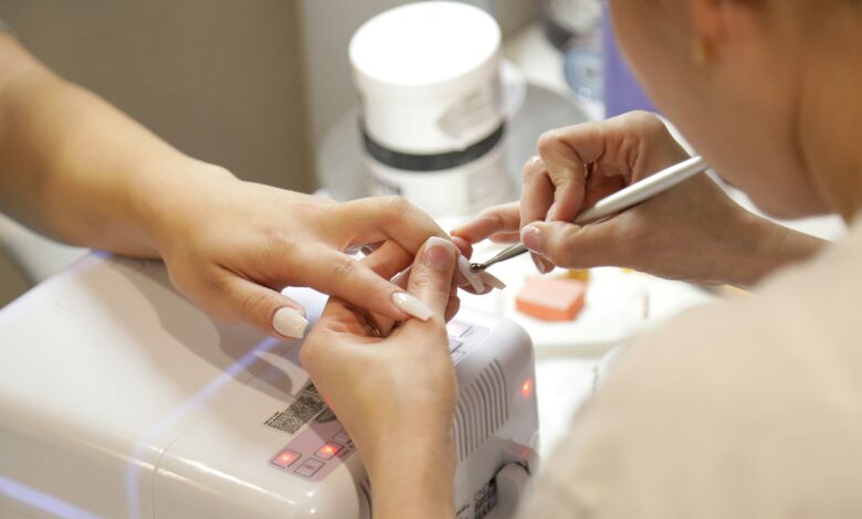 cuticle tool lifting soft gel from a nail, part of how to remove gel x nails at home