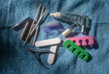 A flat lay of manicure tools like files clippers cuticle sticks and oil used for how to remove builder gel at home