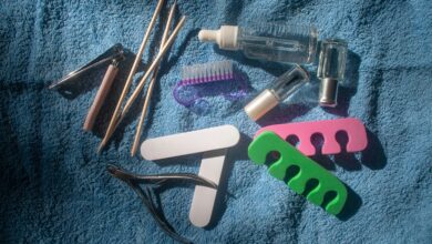 A flat lay of manicure tools like files clippers cuticle sticks and oil used for how to remove builder gel at home