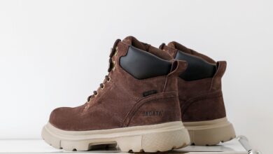 A pair of UGG boots being gently cleaned at home with a suede brush, soft cloth, and mild cleaning solution.
