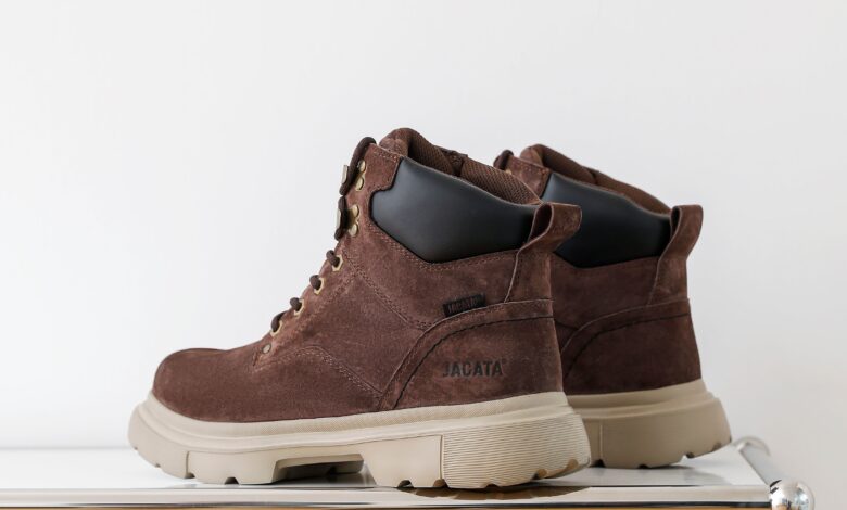 A pair of UGG boots being gently cleaned at home with a suede brush, soft cloth, and mild cleaning solution.