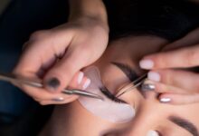 Woman gently removing eyelash extensions at home using a safe, damage-free method without pulling her natural lashes.