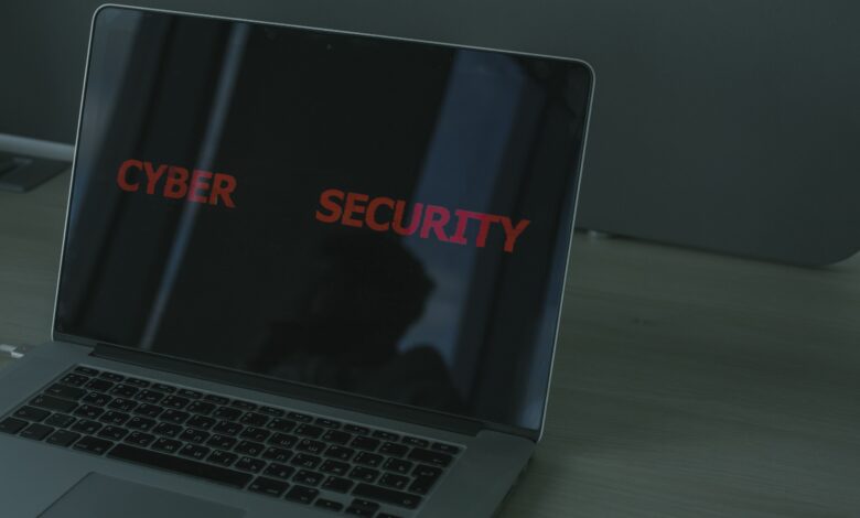 A person using a home computer with a digital security shield, lock icon, and warning symbols representing protection from cyber threats.