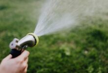 Homeowner checking a faucet with low water pressure while learning practical ways to improve water flow at home.