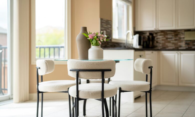 Home decor ideas for small homes shown in a cozy round dining nook with boucle chairs and a glass table
