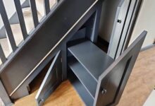 Shoe rack for under stairs built as a custom dark cabinet with angled shelves and doors