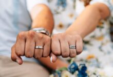 A wedding ring being safely cleaned at home using warm water, mild soap, and a soft-bristled brush