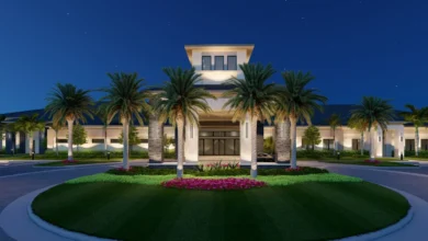 GL Homes clubhouse entrance lit up at night with palm trees and landscaped grounds