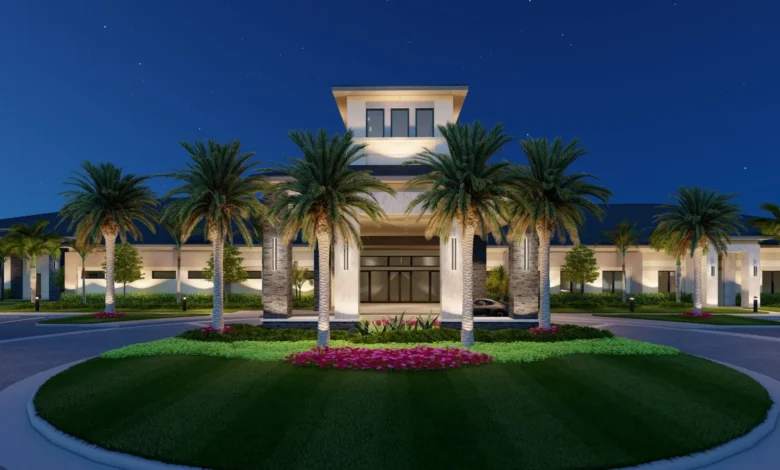 GL Homes clubhouse entrance lit up at night with palm trees and landscaped grounds